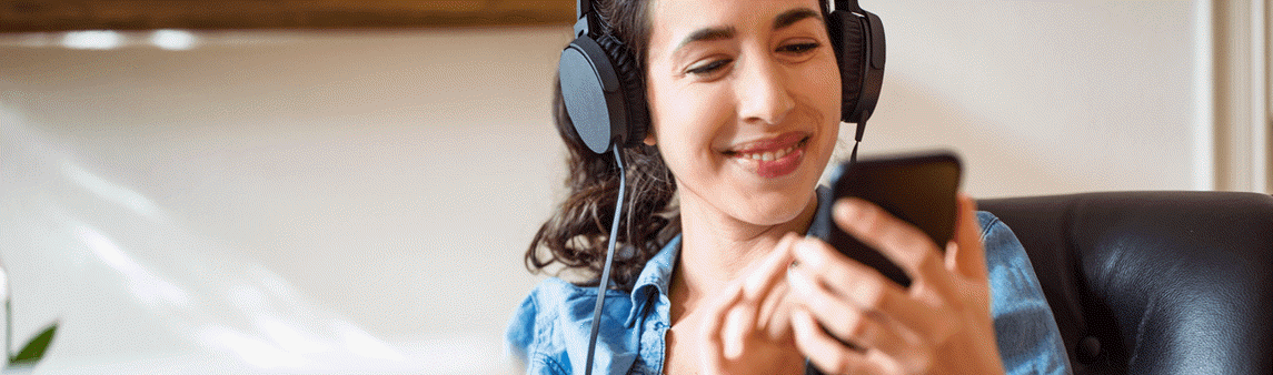 Southern Cross - Woman listening to music with headphones connected to her phone Woman listening to music with headphones connected to her phone