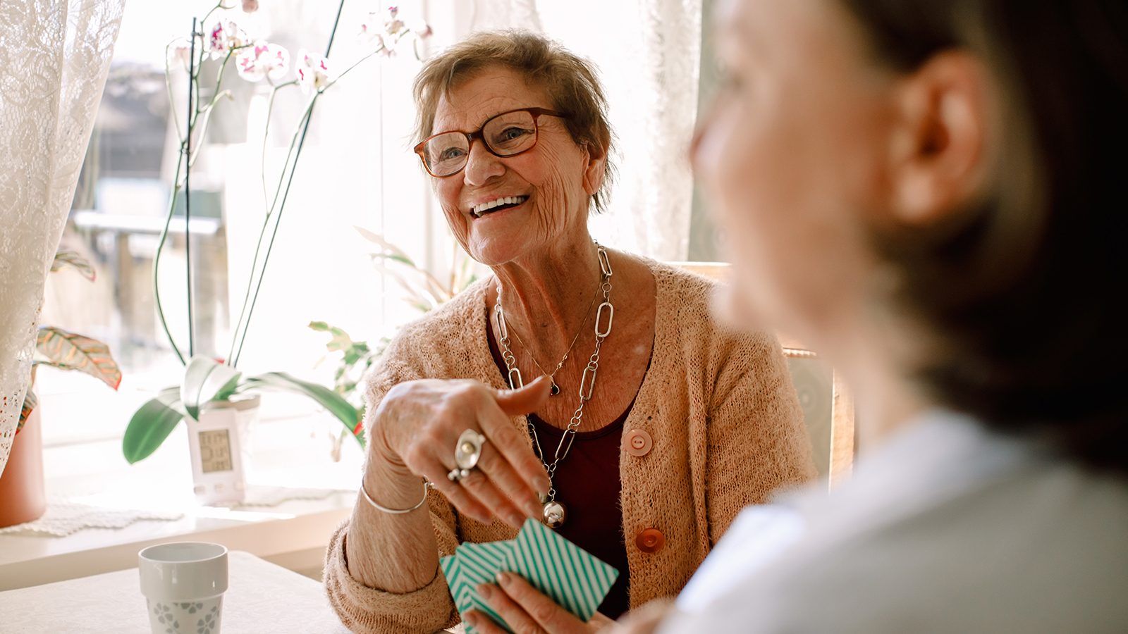Southern Cross - An elderly woman laughs while playing cards An elderly woman laughs while playing cards