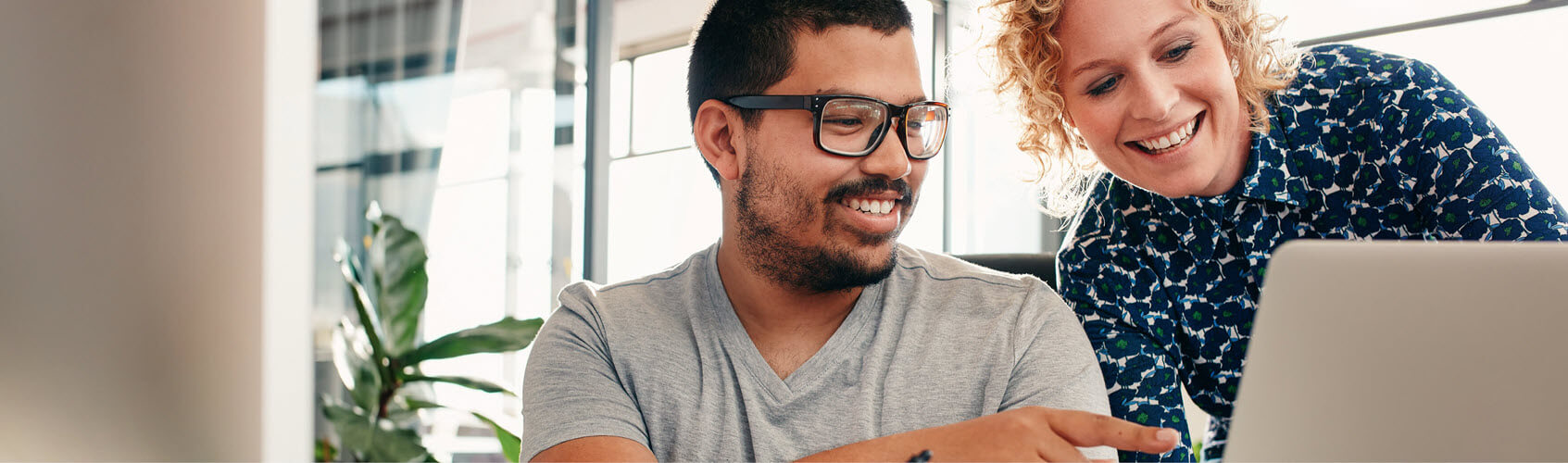 Two work colleagues looking at a laptop screen